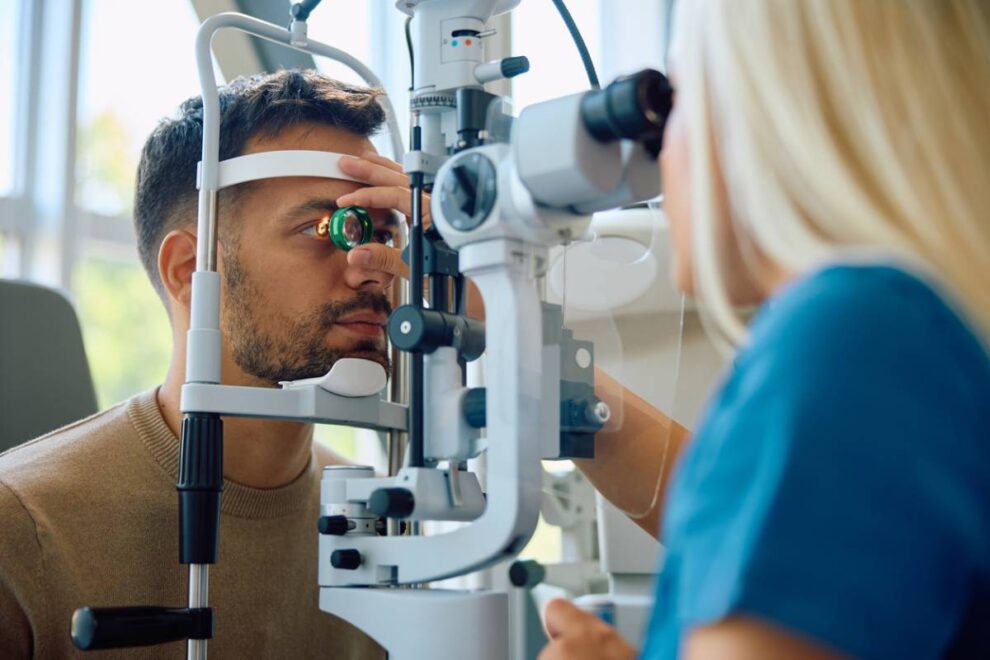 Man getting his vision tested by ophthalmologist at eye clinic.